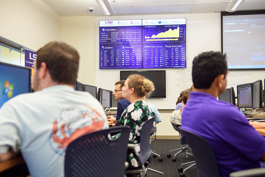 Students look at large screen with charts.