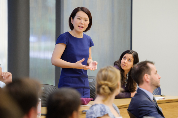 Professor Su stands at back of class for lecuture.