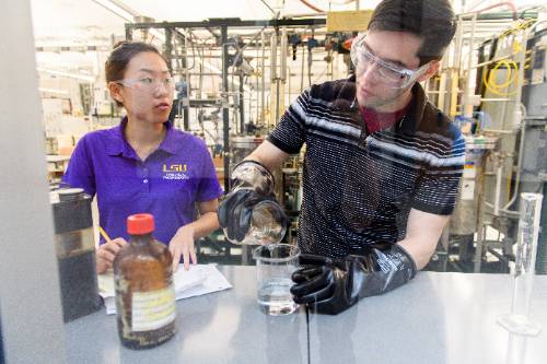 Two students with safety glasses on in a lab