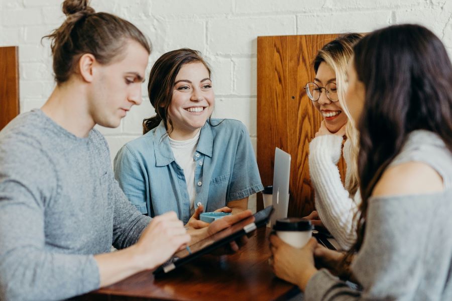 four students smile and talk