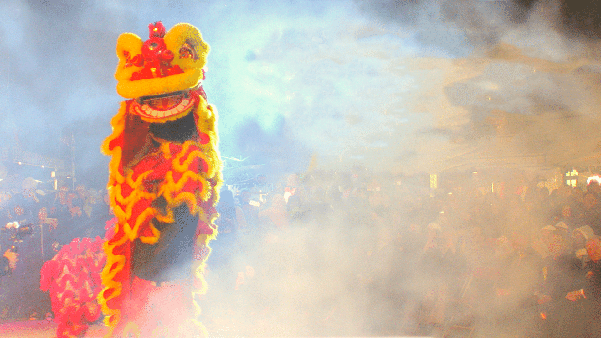 A costumed dancer and parade-goers in dark smoke during the Tet Festival in New Orleans