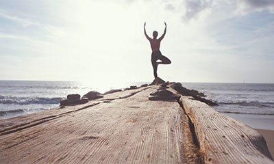 woman doing yoga outside by the beach